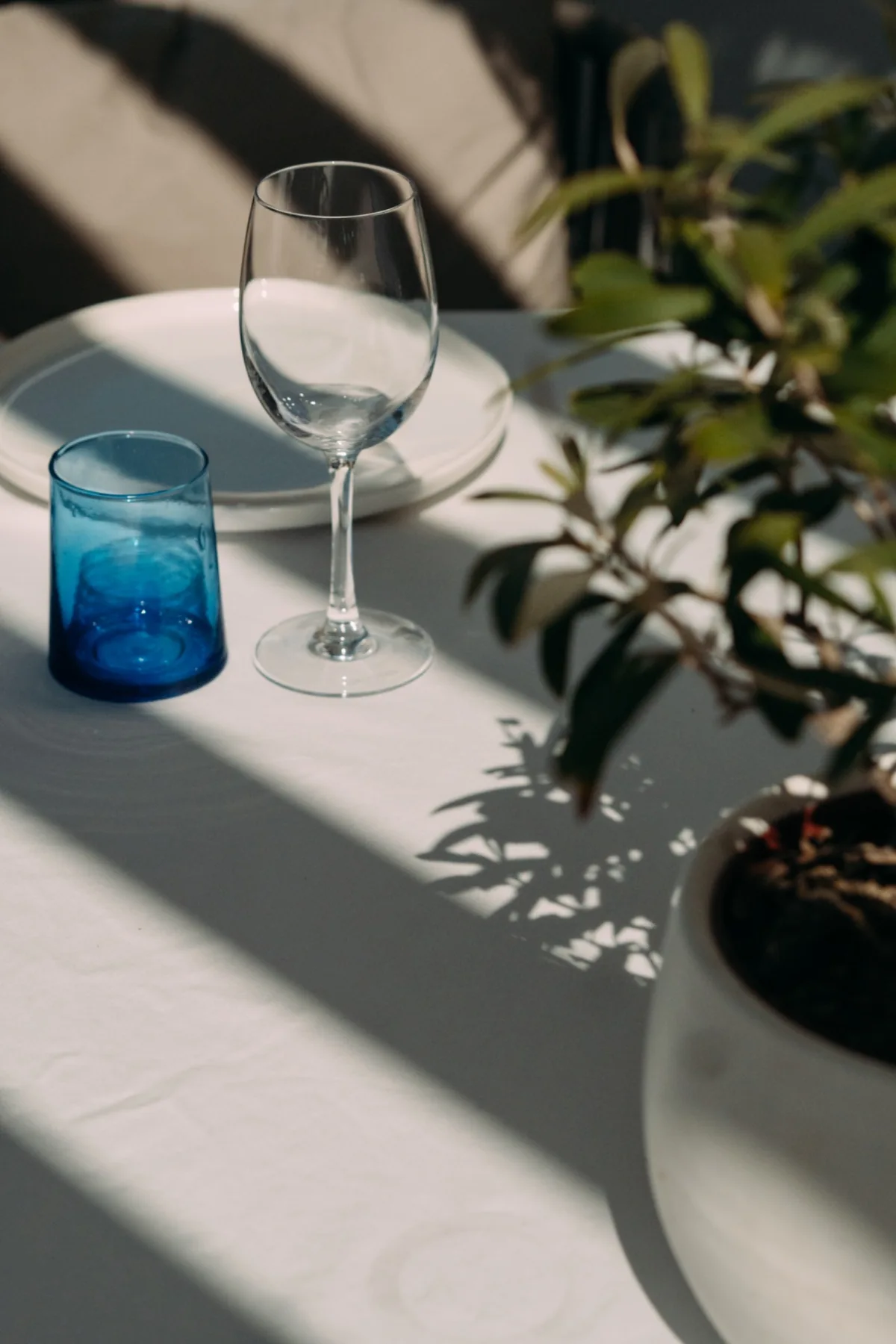 Verre et couvert dressés sur une table ensoleillée