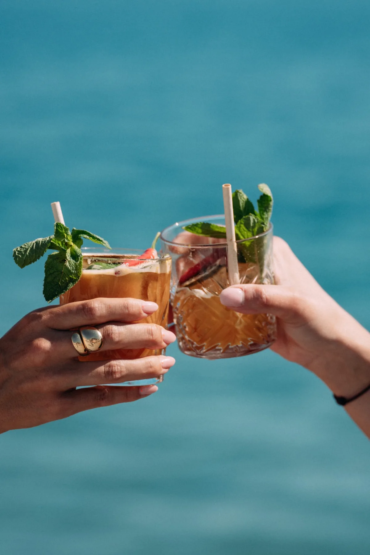 Deux cocktails levés devant la mer
