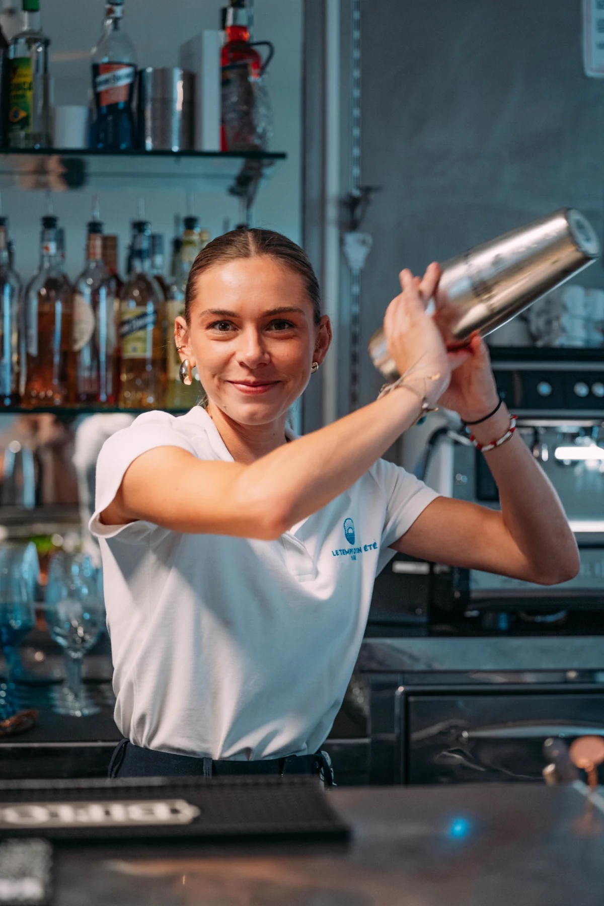 Barmaid souriante secouant un shaker