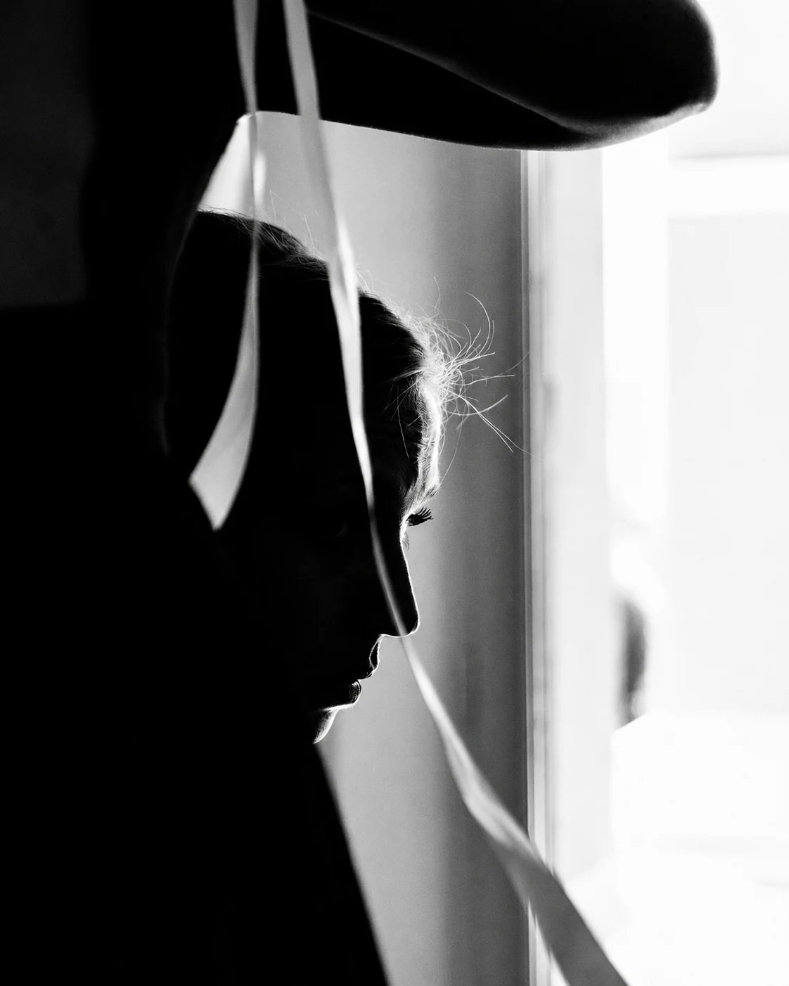 Silhouette de la mariée devant une fenêtre