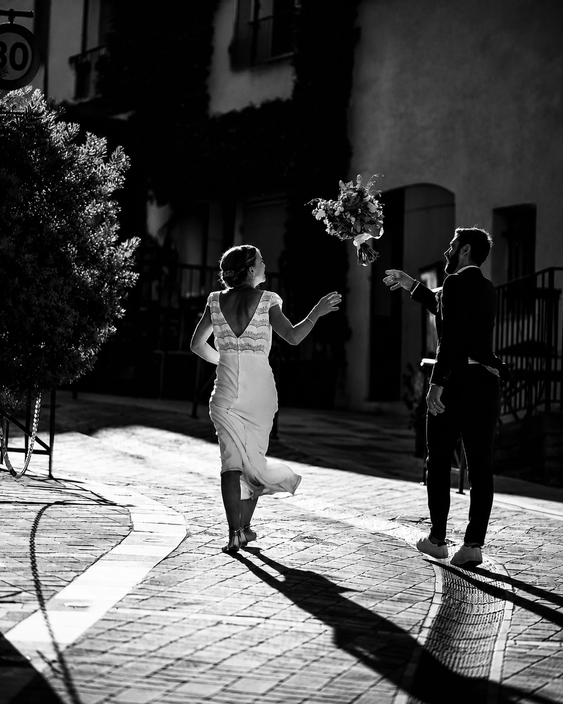 Mariés jouant avec leur bouquet en pleine lumière